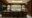 dark wooden room with bar and 6 stools and a light blue wall in the back with selection of jars