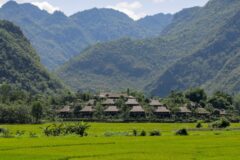 mai chau eco lodge in vietnam from the distance with hills in the back ground