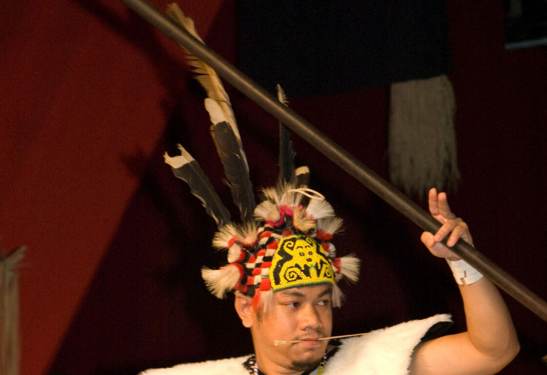 a man performing a dance in a cultural village in Sarawak