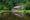 wooden traditional long house located by a small lake reflecting in the water and surrounded by greenery - Borneo