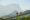 Sabahan villagers native couple walk through a hanging bridge with beautiful majestic Mount Kinabalu at background.