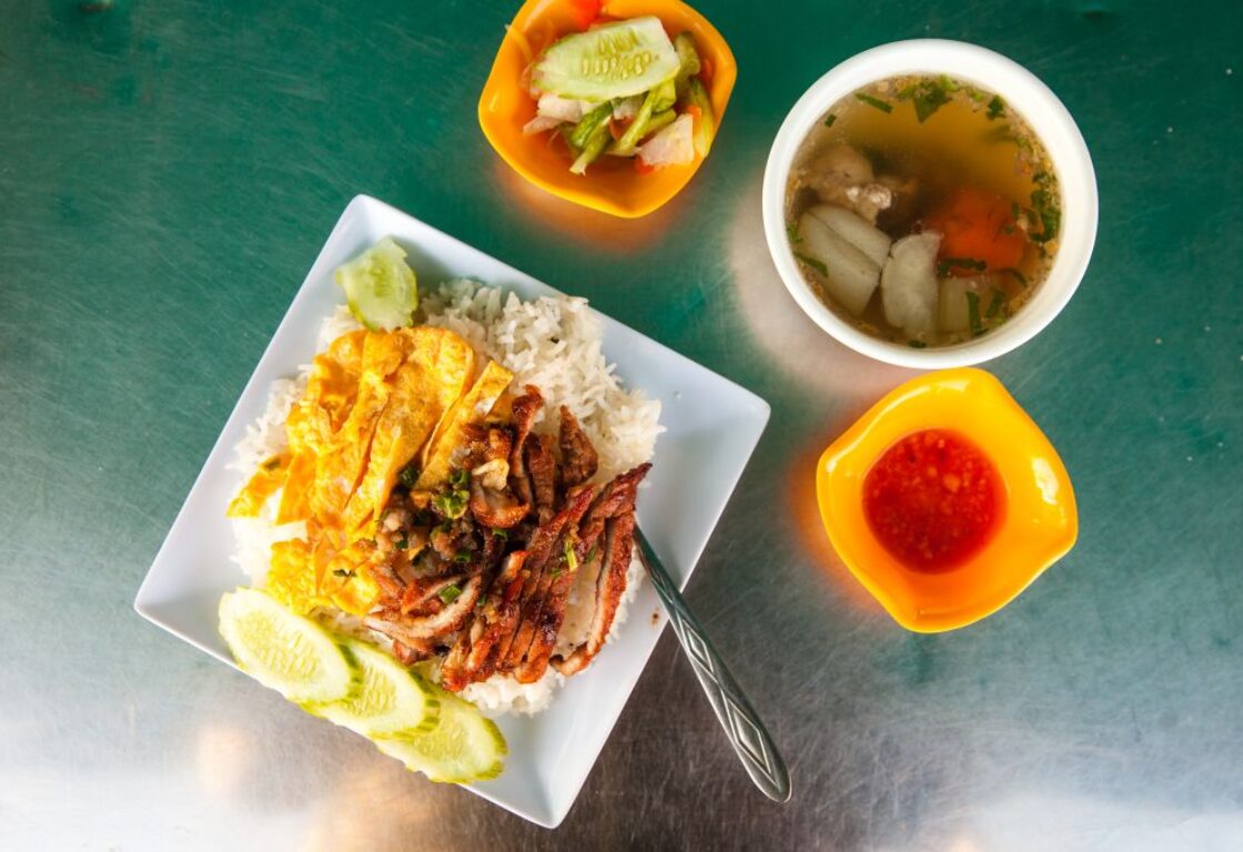 four plates of food with different sizes taken from above with different meals in cambodia