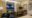 Viroth's Hotel bedroom with a door open on to a balcony and an armchair in one corner and a desk in the other