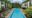 Viroth's Hotel view of the pool from above with white buildings on either side and a row of black sun loungers by the pool
