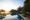 plataran menjangan in indonesia a pool with a curved edge at the end sits higher than sea level with trees dotted around and a paved area to the right of the pool