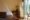 Knai Bang Chatt in cambodia a double bed covered with a mosquito net and a small wooden table in the corner with a door opening on to a balcony