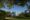 Knai Bang Chatt in cambodia a white building with columns through a clearing in the trees