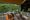 image of a cosy lounge with arm chair and sofa with colourful designs with an open view onto a river and trees at shinta mani wild in cambodia