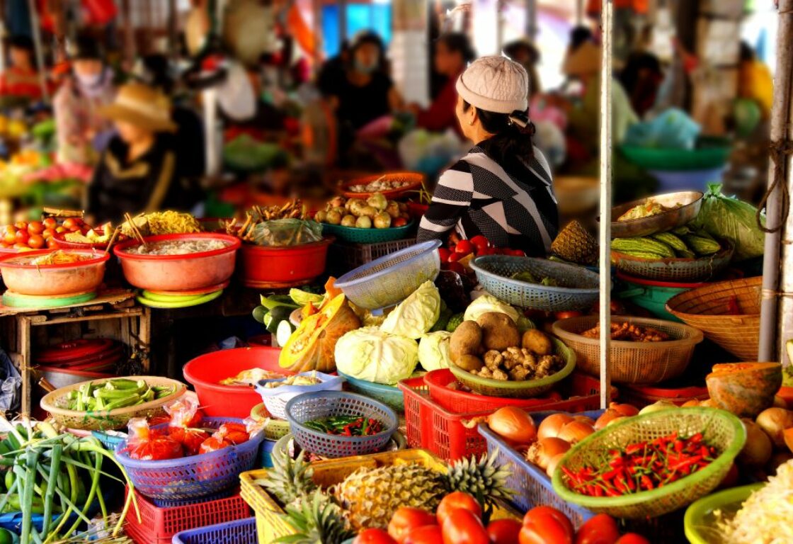 colourful market in hoi an with bowls of different fruit and vegetables