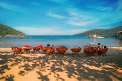 golden sand and sea stretching off to the distance with a row of chairs on the shore koh rong sanloem