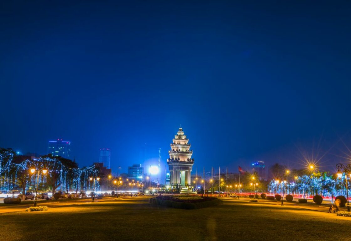 night time with a monument in the centre lit up and lights in the streets around it