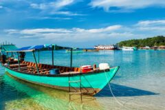 wooden boat in the shallow crystal clear water in cambodia