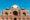 mausoleum featuring intricate red sandstone and white marble architecture, with a large central dome surrounded by beautifully landscaped gardens and symmetrical pathways under a clear blue sky in india