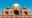 mausoleum featuring intricate red sandstone and white marble architecture, with a large central dome surrounded by beautifully landscaped gardens and symmetrical pathways under a clear blue sky in india
