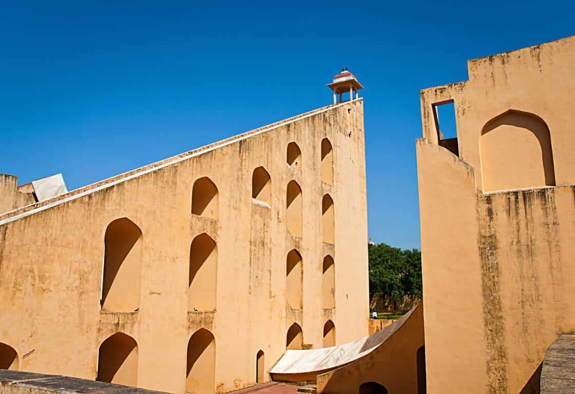 towering triangular yellow wall, with arched niches and a staircase leading to a small canopy at the top