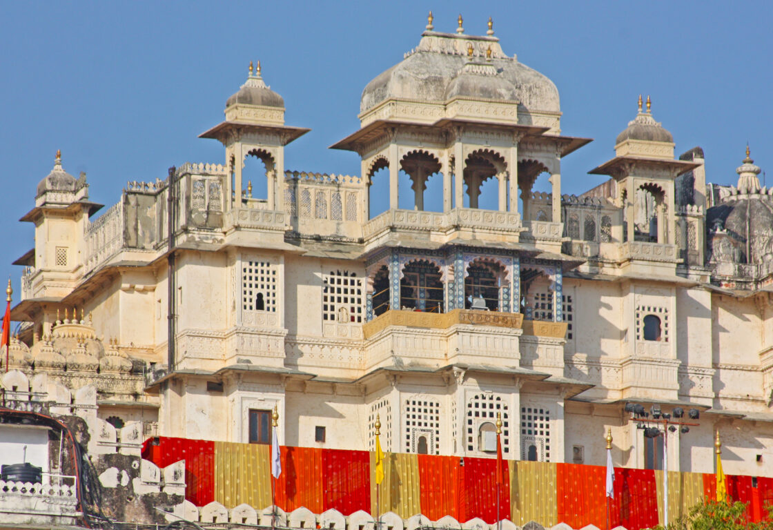 palace in india with red and yellow sheets hanging from one of the levels