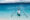 a white boat with two poles on either side to balance it sits on top of crystal clear sea in gili meno, indonesia