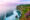 a stretch of cliff on the right hand side with lots of greenery growing and purple flowers growing in the corner and below there is the sea with white waves