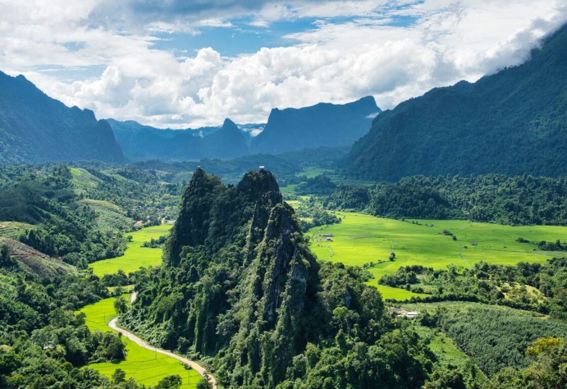 view of mountain in green countryside in vang vieng