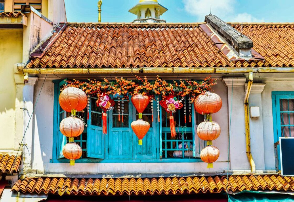 lanterns hang in front of blue shutters in chinatown, in singapore