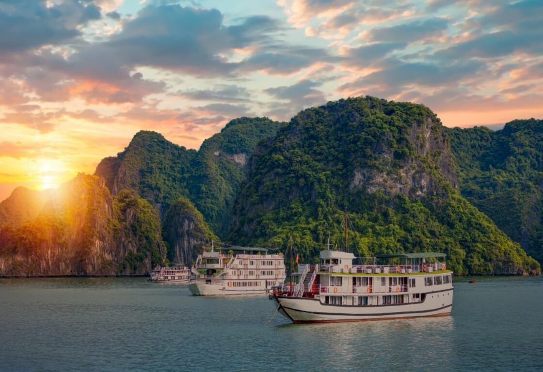 sunset in ha long bay with cruise boats moored