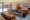 The Bale in cambodia a large double bed on the far corner with a sofa and wooden coffee table looking onto a courtyard