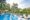 The Mansion Bali in indonesia a long pool with one edge in wave shapes and on the other side sun loungers on a platform that looks out onto a canopy of trees and forest surrounds the whole area