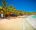 shops and huts along a stretch of perfect sand with crystal clear sea crashing onto the shore in koh rong, cambodia