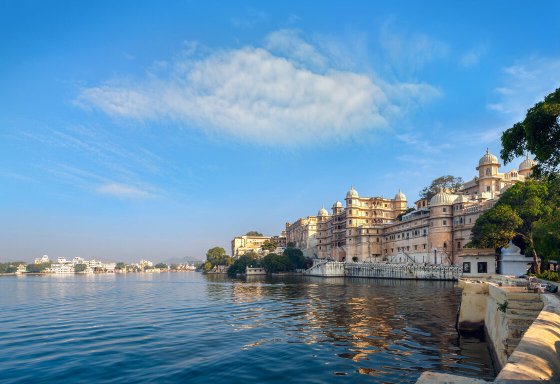 a large lake in Udaipur india with old palace buildings along the banks of the lake