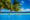 A couple relaxes at the edge of an infinity pool in the Maldives under the shade of palm trees, overlooking turquoise shallows and the deep blue ocean beyond, with a bright blue sky scattered with fluffy white clouds in the background.