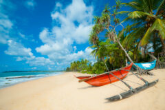 Sri Lanka beach with a red boat on shore