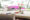 dining area outdoors with table with flowers and pink bushes in the back ground