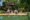 Two people realxing by a large pool at Why HOuse with a waiter serving drinks