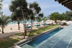 Lantern Boutique Hotel view over the pool and ocean with palm trees