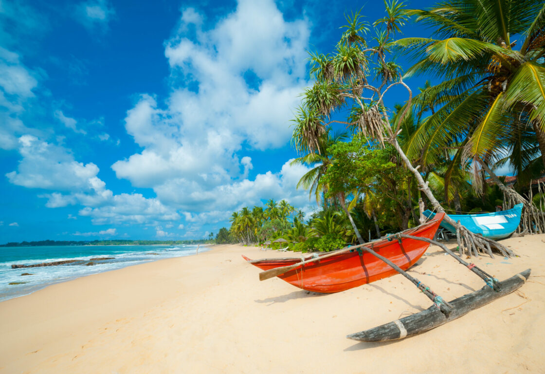 Sri Lanka beach with a red boat on shore