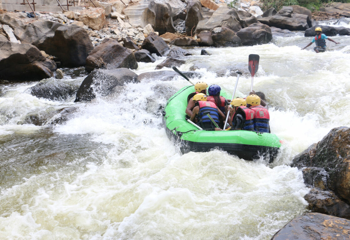 group of people are in a green raft white water rafting in Sri Lanka
