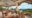Amarela Resort in the Philippines restaurant with open walls and pillars up to a white ceiling with views over a forest and the sea and in the restaurant there are sets of wooden tables with wooden chairs around them and on the fair left wall a chalkboard menu