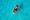 Aerial view of two people paddling a kayak on crystal-clear turquoise water, conveying a sense of adventure and tranquility.
