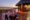 an evening dining table for two is set on a wooden seating area at the Etosha-Mountain-Lodge with table cloth, plates, candles all overlooking the nearby african bush
