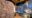 a photo of a bathroom made out of natural stone walls and the shower is curvy with dark grey paneling at Hoodia Desert Lodge
