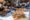 a large table set with different plates filled with salad, bread, meat quiches and severs