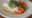 a plate with carrots, tomatoes, and a meal