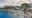 a luxury safari lodge with a large pool area, trees, loungers, sun umbrellas at sunset