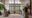 several people sitting on the mats meditating with a man sitting opposite them with a large floor to ceiling window