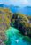 aerial view of the small lagoon in el nido where limestone cliffs create a cove separate from the rest of the sea and boat with kayaks waits in the middle of the water