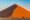 a large sand dune in namibia shaped in a triangle shape at sunset looking almost orange