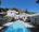 a long pool with a white hotel building at the end of it, Tabletop mountain in the background