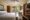 Amarela Resort in the philippines a double bed on the left hand side faces a wooden door and next to it a wooden unit with a tv on and on the far wall a single door is open and trees can be seen in the distance