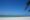 White sands meet crystal clear light blue sea and blue skies