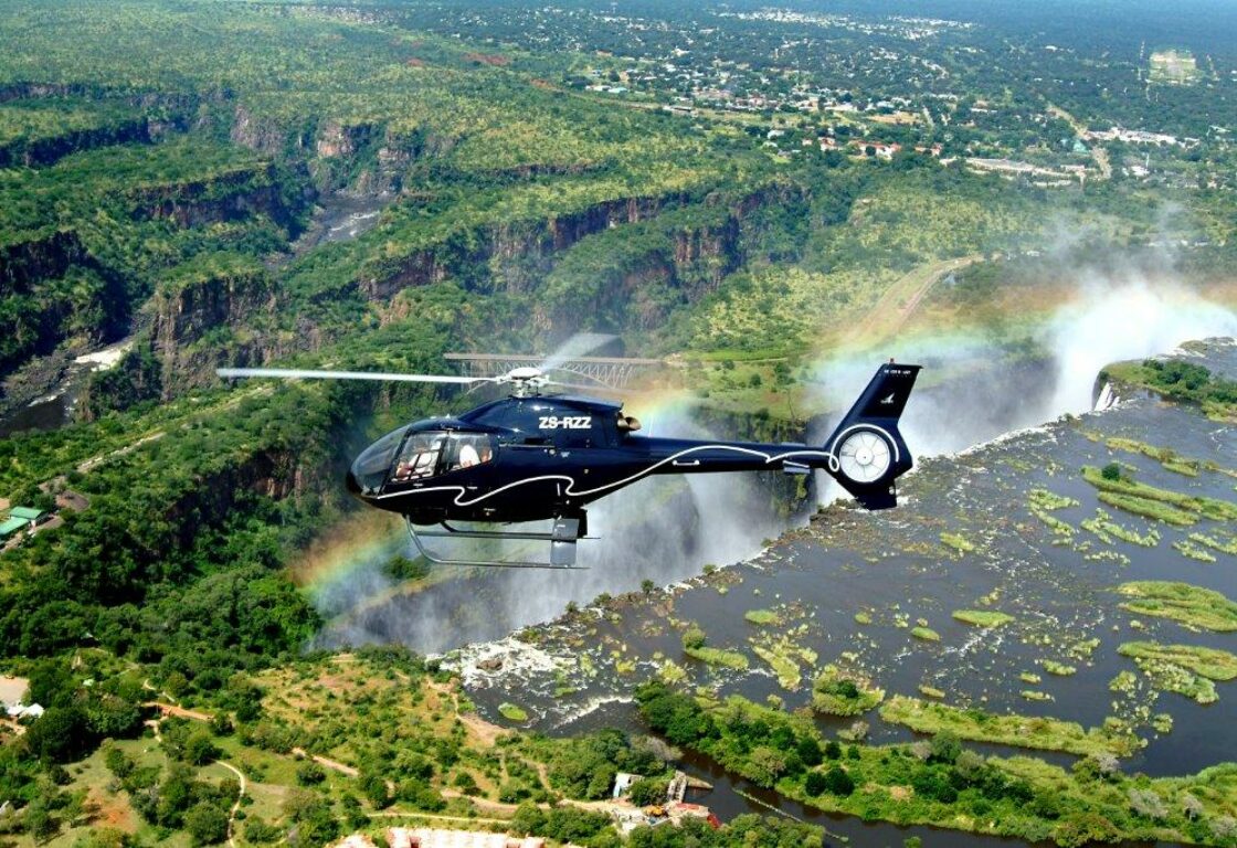 a helicopter flying over victoria falls